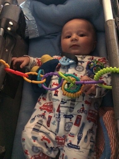 baby hugo in plane bassinet playing with toy